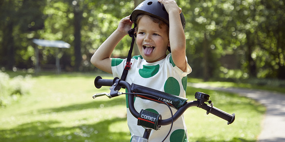 Jongetje doet helm aan om veilig te fietsen
